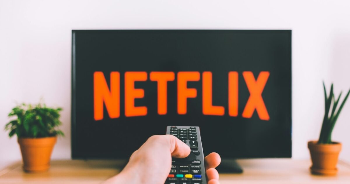 pessoa segurando controle remoto apontado para a TV