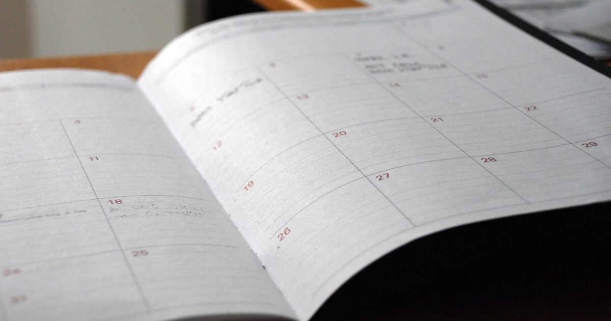 agenda mensal aberta sobre mesa de madeira